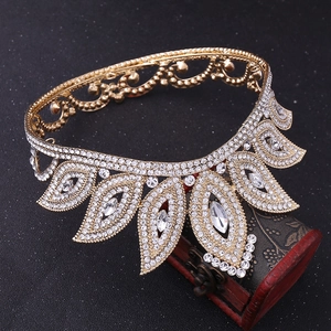 Detailed close-up of a gold baroque bridal crown with sparkling rhinestones on a wooden box