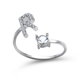 Macro shot of silver letter R ring featuring micro-pave zircons and a round solitaire stone