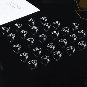 Macro shot of silver initial rings with cubic zirconia and adjustable open bands