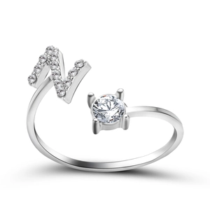 Macro view of adjustable silver letter N ring with sparkling zircons and a round center stone