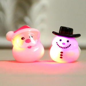 Glow-in-the-dark Christmas rings featuring Santa and snowman figures with warm pink lights