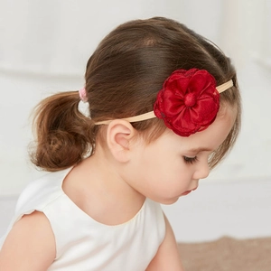 Close-up of a girl wearing a red floral fabric headband for kids on a clean background
