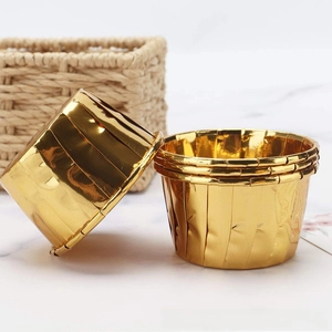 Golden foil cupcake liners with rolled rims for muffin baking on marble surface