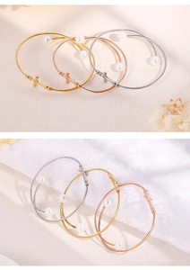Detail of three-color flexible wire bracelets with white pearls and cross charms