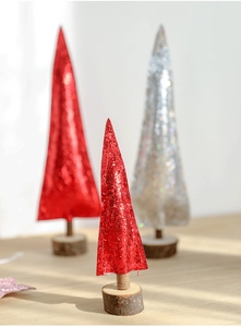 Close-up of red and silver glitter mini Christmas trees with natural wood bases