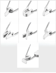 Macro detail of T-Z initial pendants in polished titanium steel with box chains