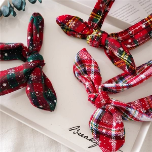 Close-up of three festive Christmas plaid headbands with snowflake patterns in a tray