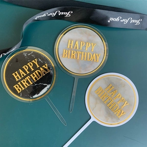 Acrylic cake topper set of three with marble texture and gold happy birthday lettering.