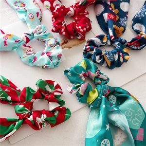 Detailed close-up of five assorted Christmas themed silk scrunchies with festive patterns