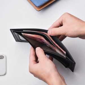 Men's trifold leather wallet in black with multiple card slots and clear ID window