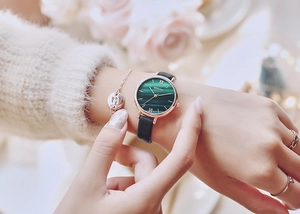 Close-up of green malachite watch face with rose gold case on model's wrist
