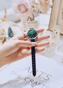 Close-up of elegant ladies watch with green malachite dial and black leather strap