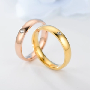 Macro shot of rose gold and gold titanium rings with minimalist single diamond settings