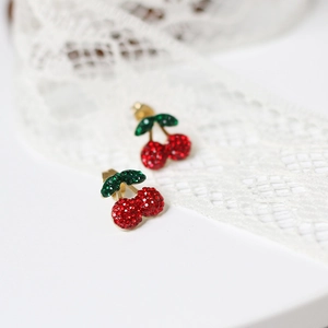 14K gold plated cherry stud earrings with red and green crystals on white lace background