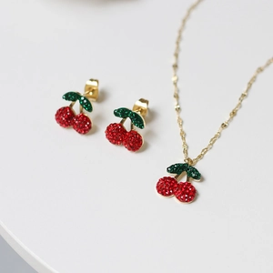 Detail view of 14K gold plated cherry necklace and earrings set with sparkling rhinestones