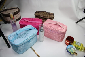 Flat lay view of multiple SOIGNE logo cosmetic bags with various skincare bottles