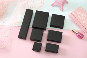 Various sizes of black textured jewelry gift boxes for necklaces and rings on colorful background