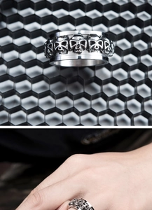 Detail of vintage silver rotating skull ring with gothic pattern on industrial background