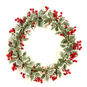 Détail d'une couronne de Noël avec feuilles de houx vertes et baies rouges sur fond blanc