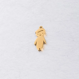Detailed macro view of a polished gold-plated stainless steel boy shape charm pendant