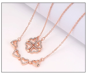 Macro detail of rose gold clover necklace with magnetic hearts and crystal inlay