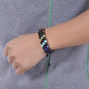 Bracelet chakra tressé avec pierres de lave et perles colorées porté au poignet