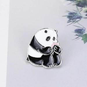Close-up of a cartoon panda enamel pin eating bamboo with a smooth polished metal finish