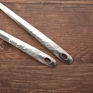 Heavy duty stainless steel soup spoons with leaf pattern handles on dark wood background