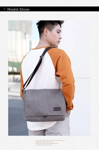 Outdoor shot of a grey canvas messenger bag with flap and adjustable shoulder strap