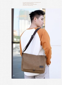Close-up of a durable dark brown canvas messenger bag with metal buckle and logo patch