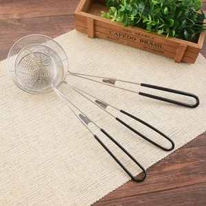 Set of three stainless steel mesh strainers with black handles on a rustic background
