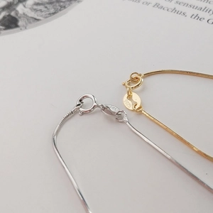 Close-up of S925 sterling silver spring clasp detail on gold and silver snake bone chain
