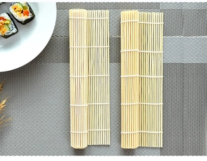 Detailed top view of natural bamboo sushi rolling mats on a woven dining mat