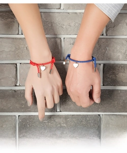 Detail of red and blue braided PU cord bracelets with silver heart charms on wrist