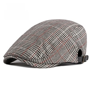 Detail view of plaid ivy cap showing side brown leather adjustable strap with metal buckle