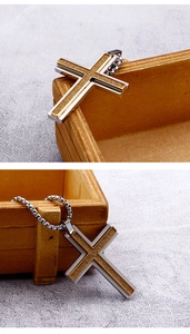 Macro detail of silver and gold stainless steel double cross necklace with matte texture