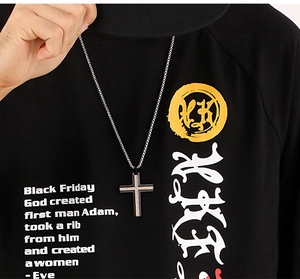 Close-up of double-layer black cross pendant with silver trim on a male model