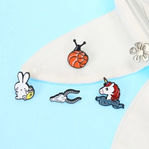 Set of four cute cartoon enamel pins including snails and rabbits on blue background