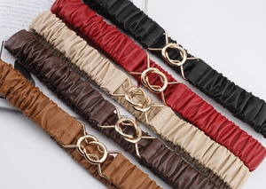 Detail of multi-color elastic pleated waist belts with interlocking gold buckles