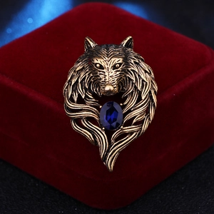 Retro bronze wolf head brooch with blue gemstone on red velvet jewelry box