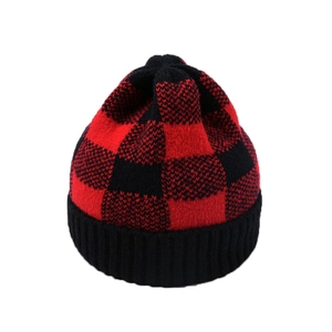 Close-up of red and black buffalo plaid pattern and ribbed knit texture on winter hat