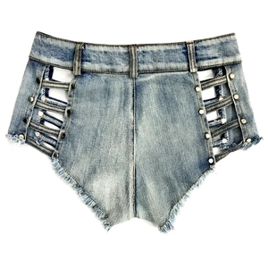 Dettaglio di pantaloncini di jeans con ritagli laterali e rivetti in metallo su tessuto blu