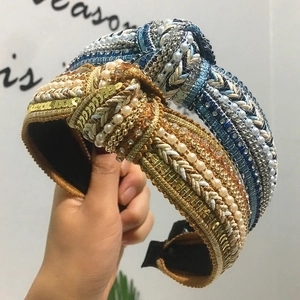 Detail of twisted fabric headbands with sequins, faux pearls, and rhinestones in retro style