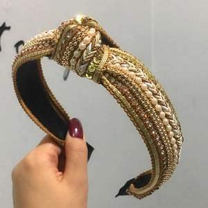 Golden sequin and pearl headband featuring a twisted knot design for women