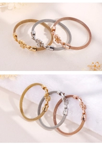 Detailed view of woven mesh bracelets in gold, silver and rose gold with floral charms