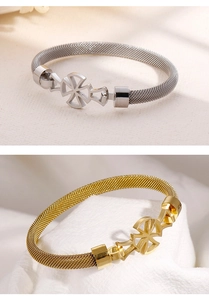 Detailed close-up of woven mesh metal bracelets in silver and gold with circular charms