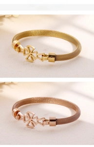 Detail of gold and rose gold stainless steel mesh chain bracelets with floral charms