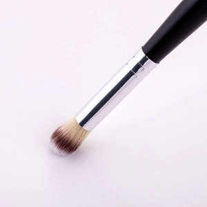 Gros plan d'un pinceau de maquillage bicolore avec un manche noir élégant