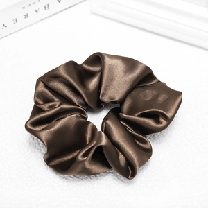 Detailed view of dark brown satin scrunchie showing silky texture and elegant folds
