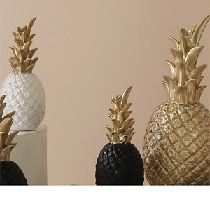 Detailed trio of Nordic pineapple ornaments in gold, white, and black finishes
